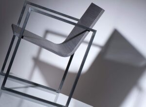 Barová židle B03 s dominantním sedákem, který je vyroben z plechu ručně tepaným v ohni. VLADAN BĚHAL DESIGN