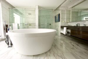 Z koupelny se solitérem v podobě vany je vidět prosklenou stěnou k bazénu. 